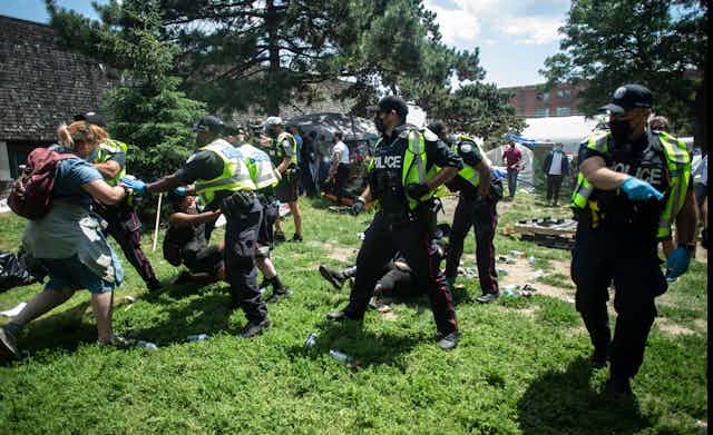 Police and protesters fight in a park.