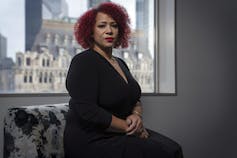 Nikole Hannah-Jones poses for a photo sitting in front of a window.