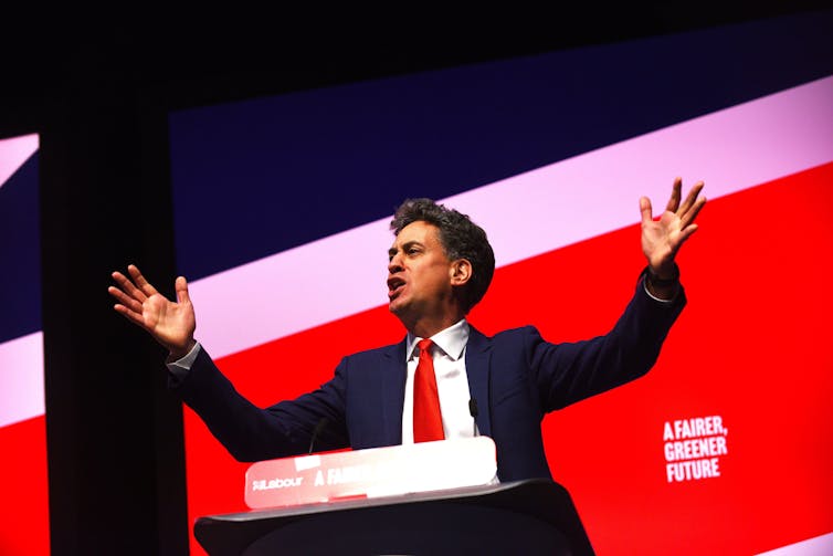Ed Miliband making a speech, waving his arms in the air.