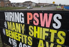An outdoor sign reading 'Hiring PSWs - many shifts - benefits'