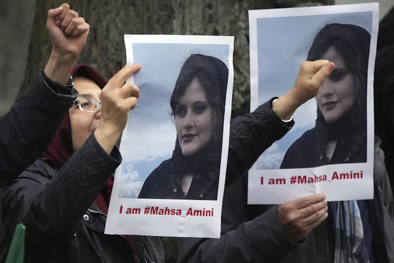 Exile Iranians of the National Council of Resistance of Iran gather in front of the embassy of Iran in Berlin, Germany, Tuesday, Sept. 20, 2022 after the death of an Iranian woman held by the country's morality police