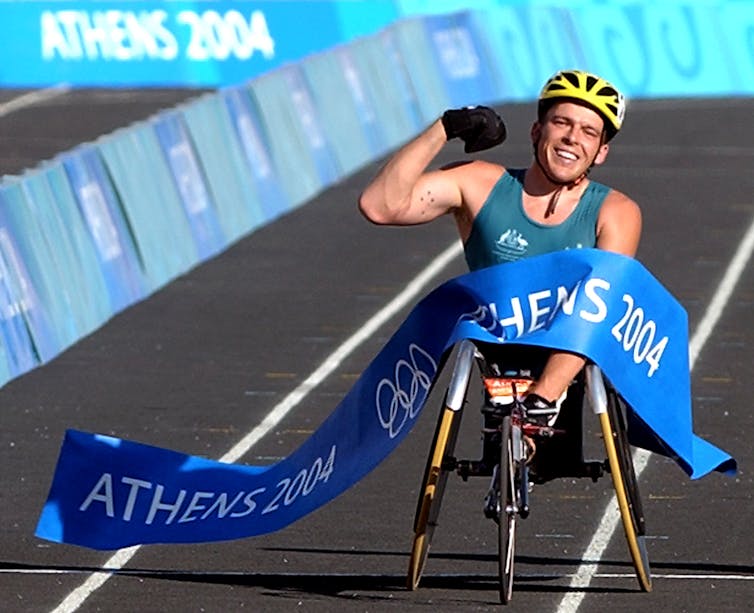 man in wheelchair finishes paralympic race