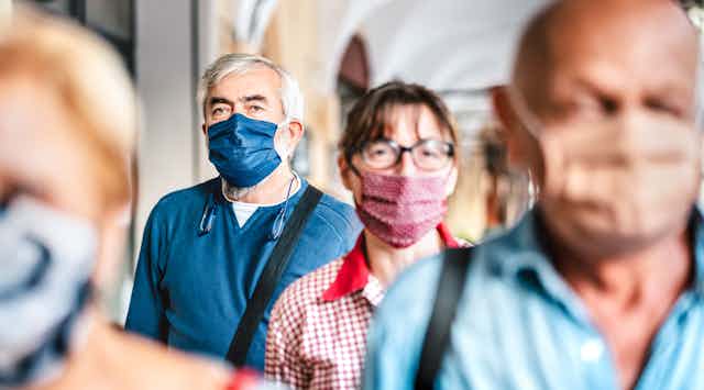 a row of people wearing surgical face masks