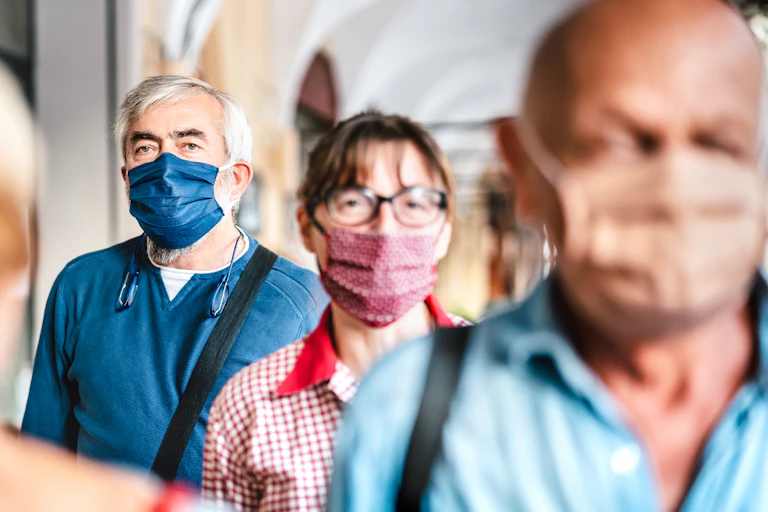 a row of people wearing surgical face masks