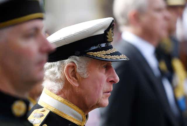 Side view of King Charles in military dress during the state funeral procession for his mother, Queen Elizabeth II