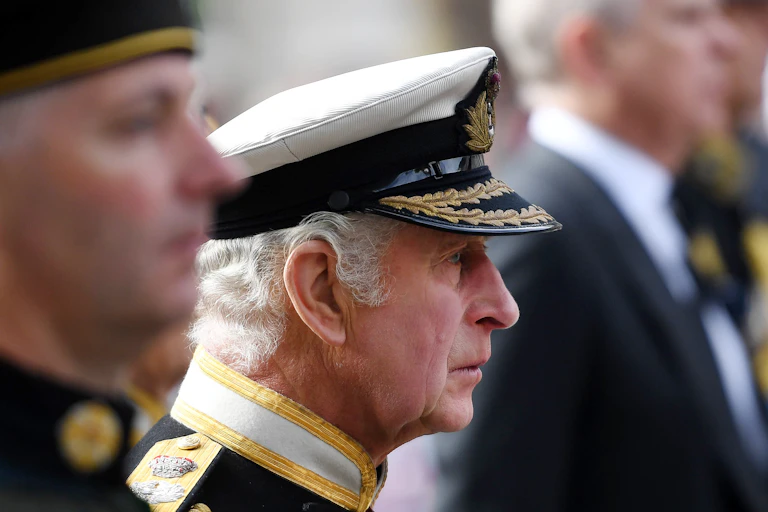 Side view of King Charles in military dress during the state funeral procession for his mother, Queen Elizabeth II