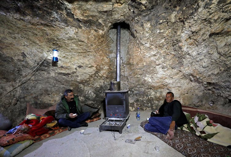 Two men talking inside a cave