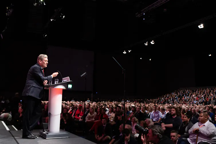 Keir Starmer on the podium and a view of the crowd at party conference.