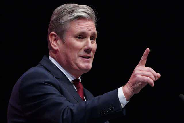 Keir Starmer making a speech, holding his finger in the air. 