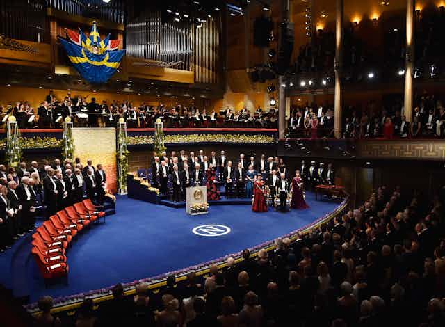 view of the Nobel Prize ceremony stage with people dressed in black tie