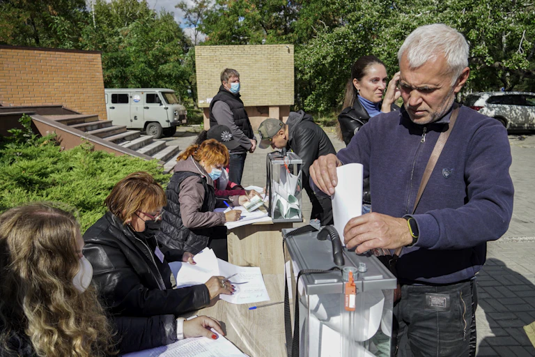 A man casts a vote in a referendum on the joining of Russian-controlled regions of Ukraine to Russia, at an outdoor polling station in Mariupol, eastern Ukraine, 25 September 2022