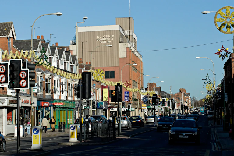 A street with decorations, cars, and shops.