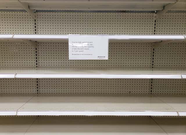 Shelves are empty with a sign explaining it's due to high demand and limiting how much people can purchase at once