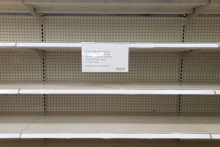 Shelves are empty with a sign explaining it's due to high demand and limiting how much people can purchase at once
