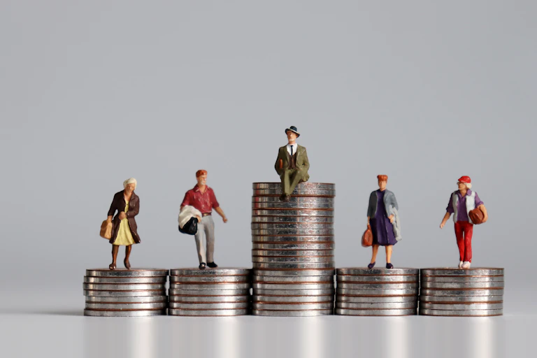 Figurines placed on tops of variously high stacks of coins