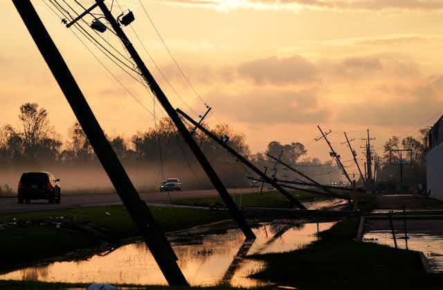 A row of downed powerlines slants across the road after Hurricane Ida in 2021