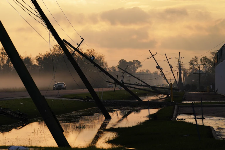 A row of downed powerlines slants across the road after Hurricane Ida in 2021