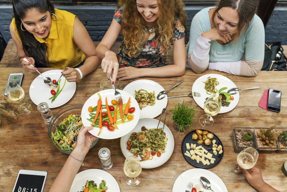 A group of young women eating healthy food at a restaurant.
