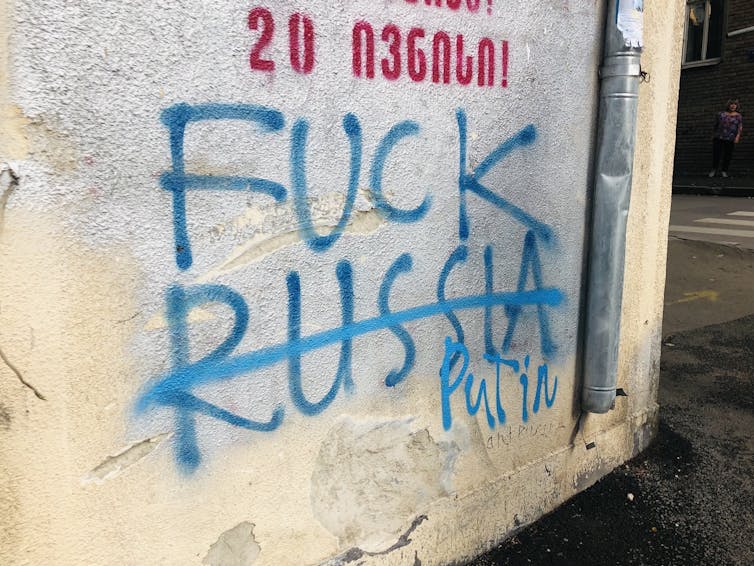 Graffiti on a wall in Tbilisi that has been changed from 'Fuck Russia' to 'Fuck Putin'.