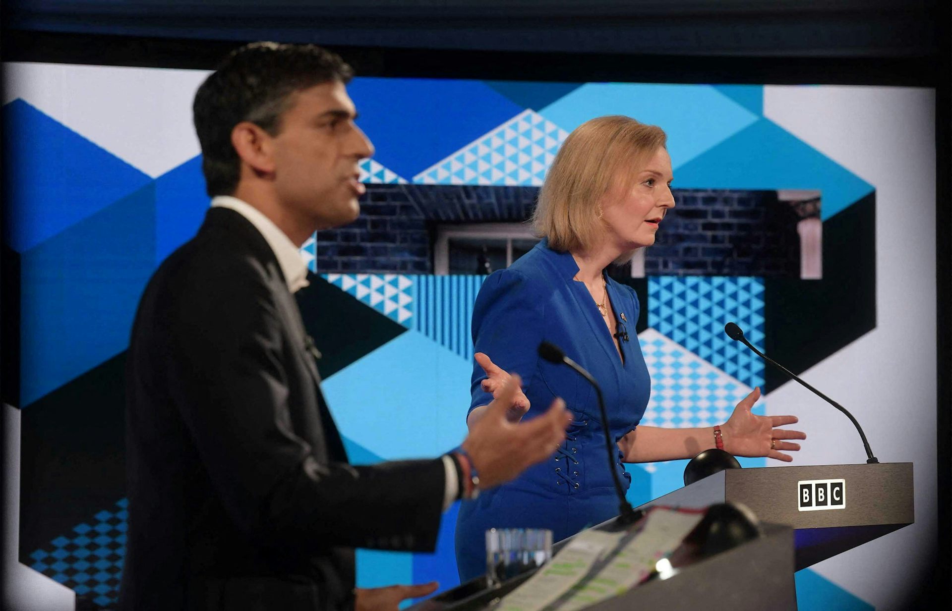 Rishi Sunak and Liz Truss speaking at podiums during a leadership debate.