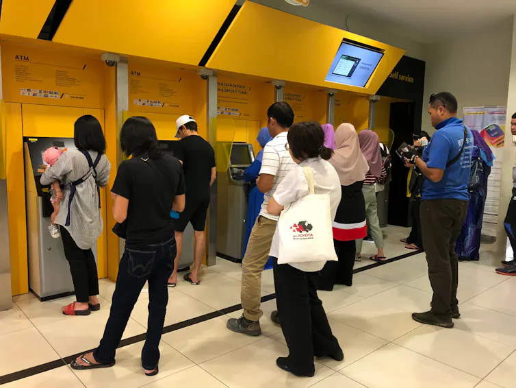 customers line up in front of bank machines