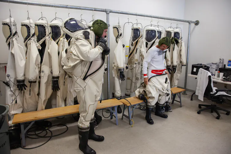 two astronauts suiting up