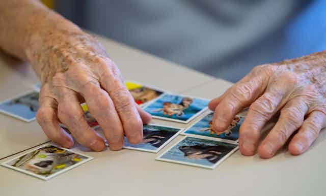 A older person's hands seen playing a game of memory.
