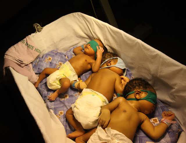  Young babies sleep together under a heat lamp at the Lagos Island Maternity Hospital, Lagos, Nigeria 