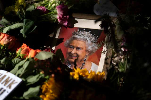 Floral tributes around framed photo of Queen Elizabeth