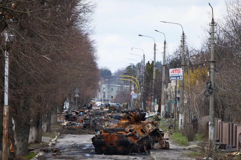 Remains of tanks in a tree-lined streets.