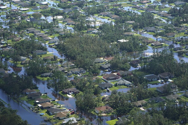 Homes across entire neighborhoods seen from a helicopter are surrounded by floodwater.