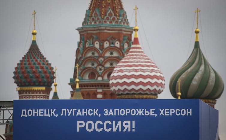 A sign outside St. Basil's Cathedral in downtown Moscow reading 'Donetsk, Luhansk, Zaporozhye, Kherson, Russia!'