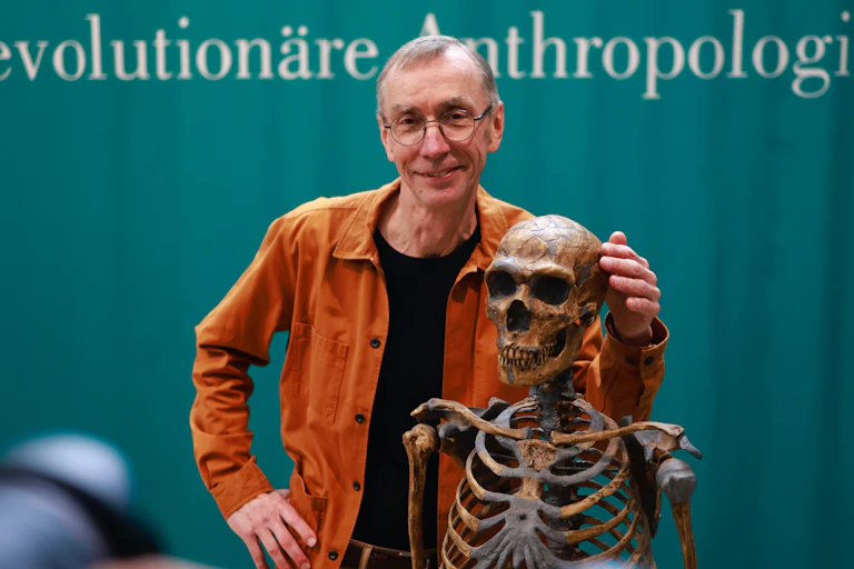 Nobel prize winner Svante Paabo poses with a skeleton.