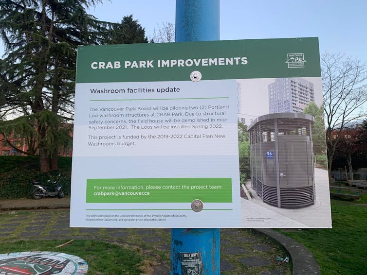 A sign, titled 'Crab Park Improvements,' shows an image of and describes a public bathroom that will be piloted in the area.