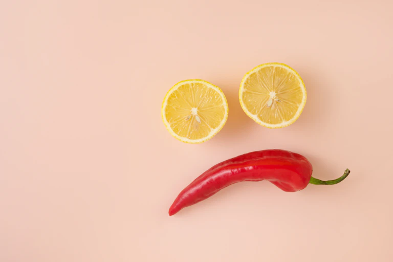 Sad face made out of lemons for eyes and a chilli for the mouth.