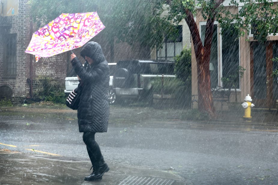Une personne traversant la rue sous la pluie battante