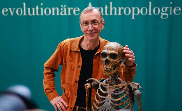 Le prix Nobel Svante Paabo pose avec un squelette.