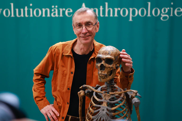 Le prix Nobel Svante Paabo pose avec un squelette.