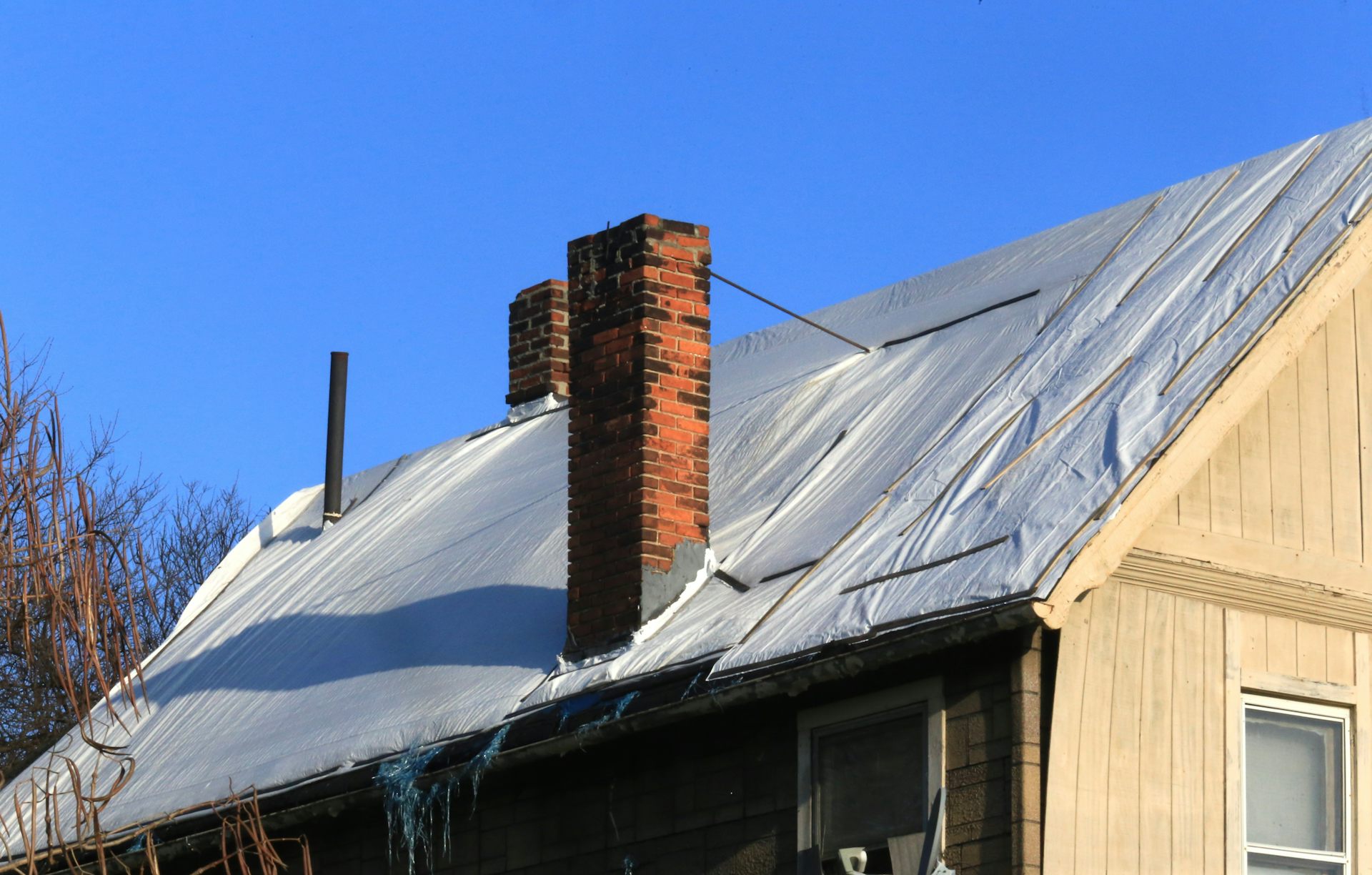 The roof of a building is covered in plastic tarp.