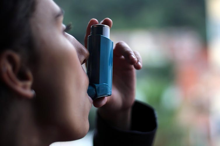 Person uses an asthma inhaler
