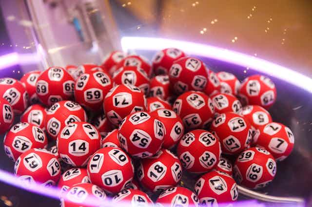 A close-up view of a pile of red lottery balls, randomly numbered