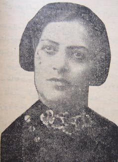 A black and white portrait of the head of a woman with ear-length dark hair, with a serious expression.