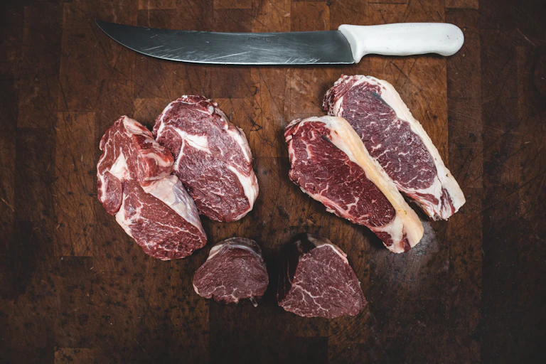 Large raw steaks and a big knife