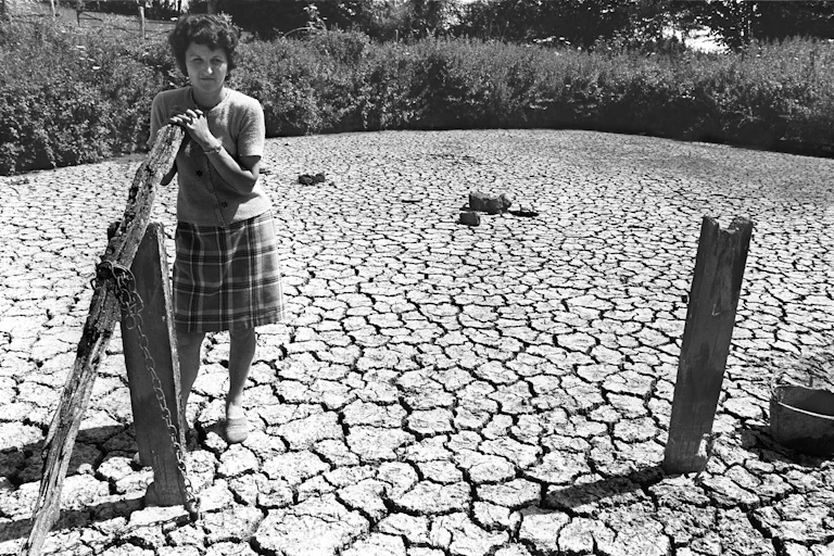 Une agricultrice sur un sol craquelé