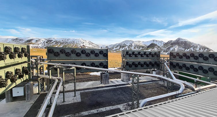 Bloques con colectores de aire con montañas nevadas al fondo.