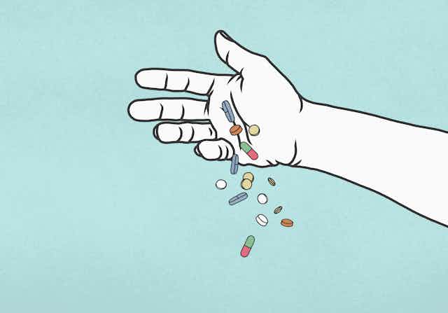 Hand releasing multicolored pills.
