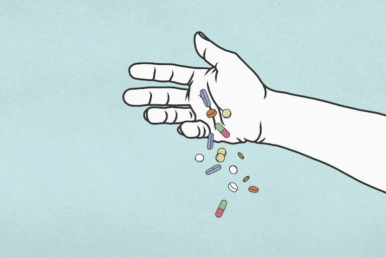 Hand releasing multicolored pills.