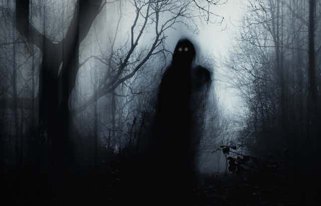 A dark, gholstly figure seen walking in a dark woods.