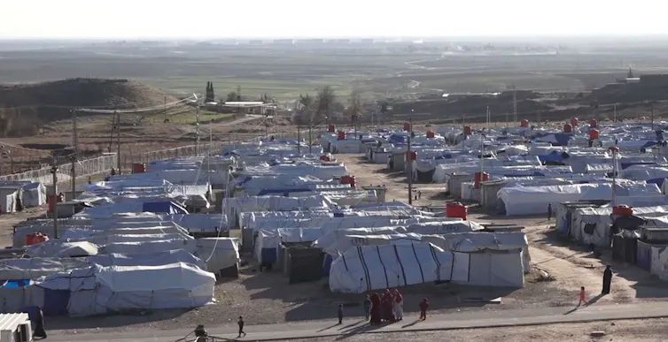 aerial view of white tents and large scale detention camp