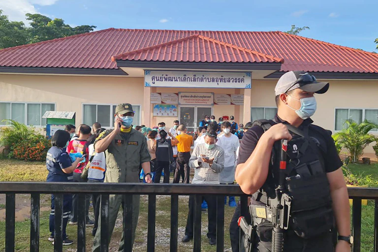 An armed guard outside a childcare centre where relatives of the victims of a massacre gather